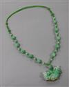 A carved jade pendant on a hardstone bead and rope necklace, pendant 50mm.                                                             