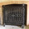 A large wrought iron scrollwork and wire mesh chimney piece spark guard, approx. W.4ft 10.5in. x 3ft 11.75in.                          