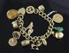 An 18ct gold curblink charm bracelet hung with fifteen assorted charms including 9ct gold and gold plated.                             