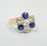 A modern 18ct gold, four stone diamond and three stone sapphire set flower head cluster ring, size J, gross weight 4.1 grams.                                                                                               