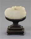 A Chinese white jade 'lion-dog' plaque, 18th century, 6cm, wood stand                                                                  