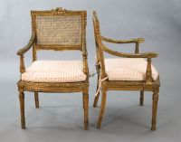 A pair of Louis XVI style walnut giltwood fauteuils, W.1ft 10in. D.1ft 9in. H.3ft 1in.                                                 