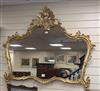 A carved gilt-framed shaped wall mirror W.130cm                                                                                        