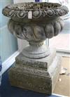 A pair of reconstituted stone garden urns, of campana shape, raised on stepped plinths                                                 