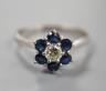 A modern 18ct white gold, single stone diamond and six stone sapphire set flower head cluster ring, size R, gross weight 3.7 grams.                                                                                         