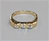 A yellow metal and collet set three stone diamond ring, size P.                                                                        