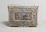 A 19th century continental gilt white metal rectangular bombe shaped snuff box, embossed with foliate scrolls and central stag hunting scene, unmarked, 81mm.                                                               