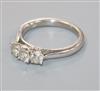 A modern 18ct white gold and three stone diamond ring, size M.                                                                         