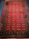 A Bokhara style red ground rug 245 x 156cm                                                                                             