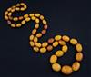 A single strand graduated oval amber bead necklace, 95cm.                                                                              