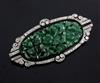 A 1920's/1930's Art Deco white gold?, pierced carved jadeite, diamond and black onyx set oval brooch, 53mm.                            