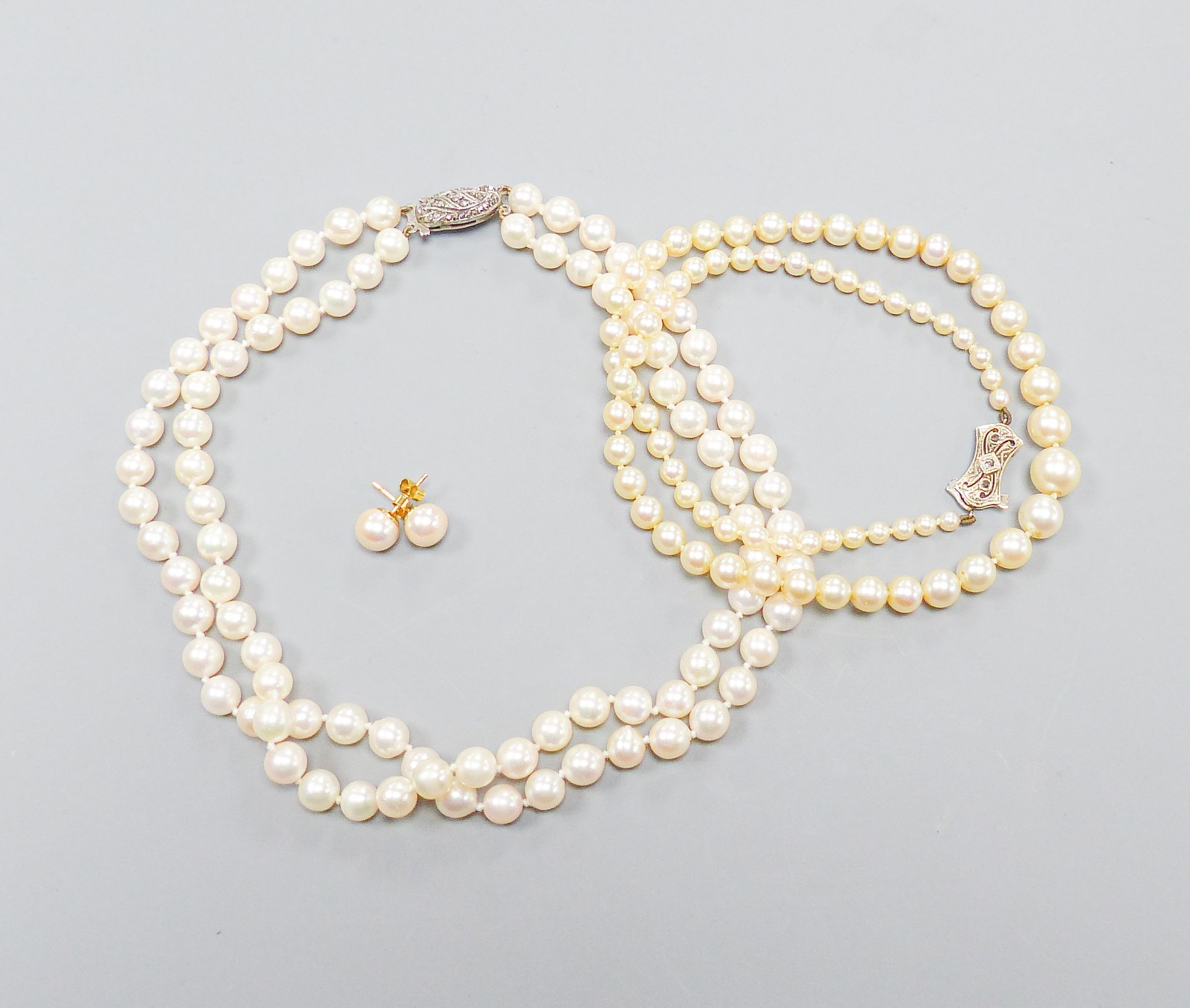 A single strand graduated cultured pearl necklace, with diamond set 9ct clasp, 43cm, a double strand cultured pearl choker necklace, with marcasite set clasp, 32cm and a pair of cultured pearl ear studs.