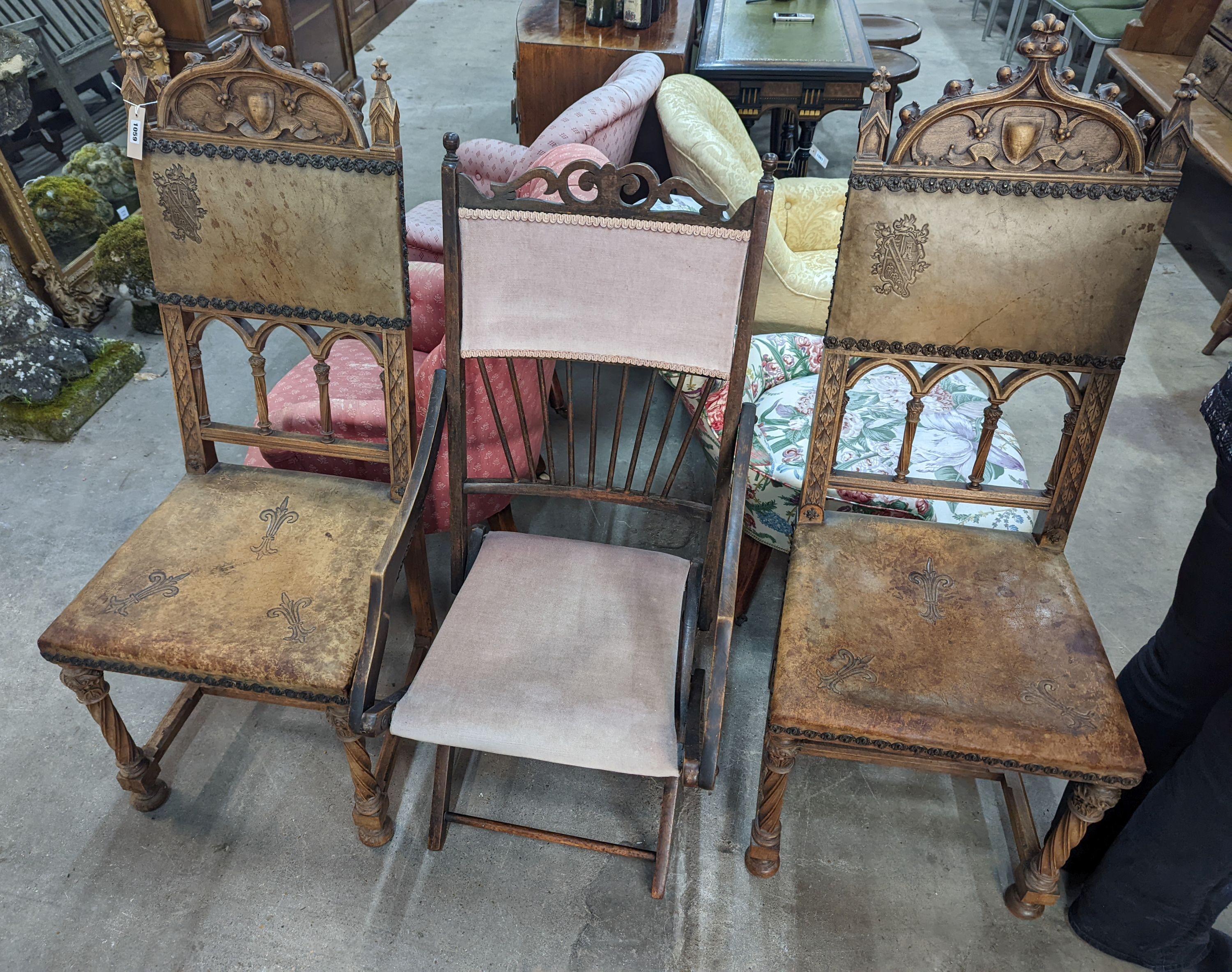 A pair of Gothic style carved walnut and leather side chairs together with an Edwardian beech folding chair