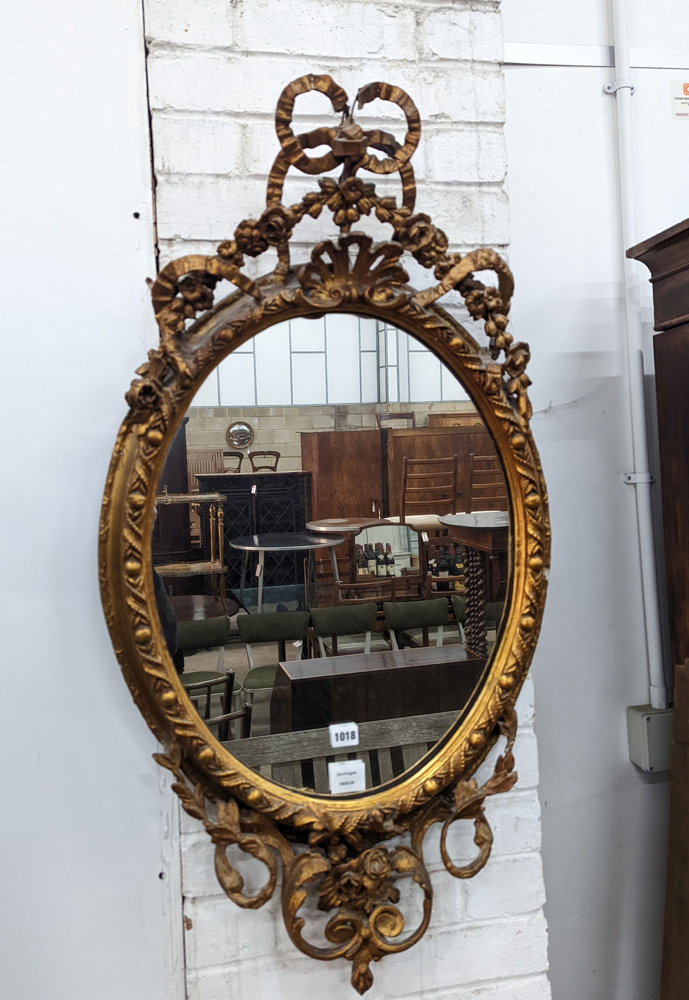 A late Victorian giltwood and gesso oval framed wall mirror, width 54cm, height 100cm