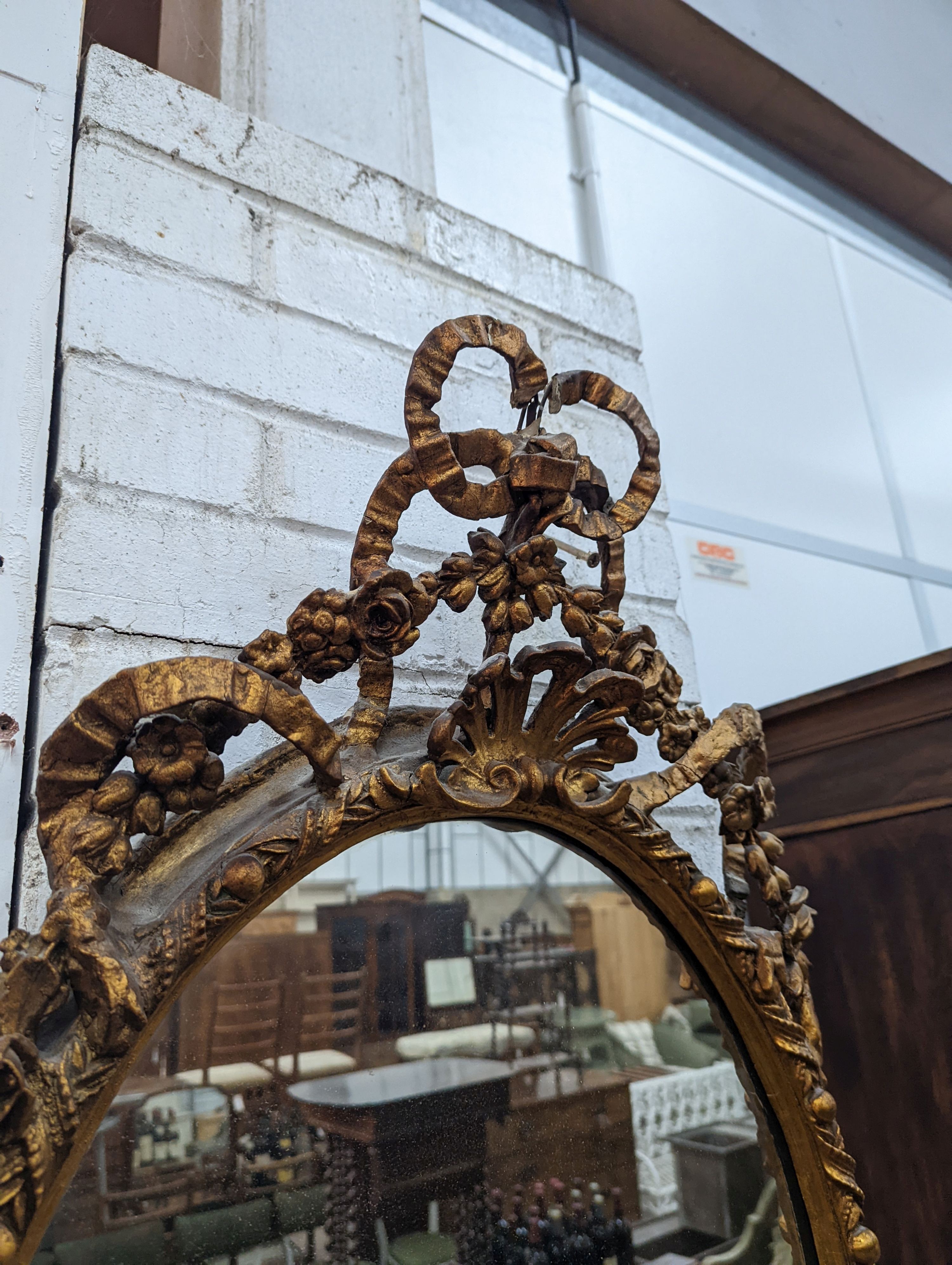 A late Victorian giltwood and gesso oval framed wall mirror, width 54cm, height 100cm