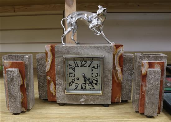 An Art Deco clock garniture with silvered bronze dog surmount An Art Deco clock garniture with silvered bronze dog surmount