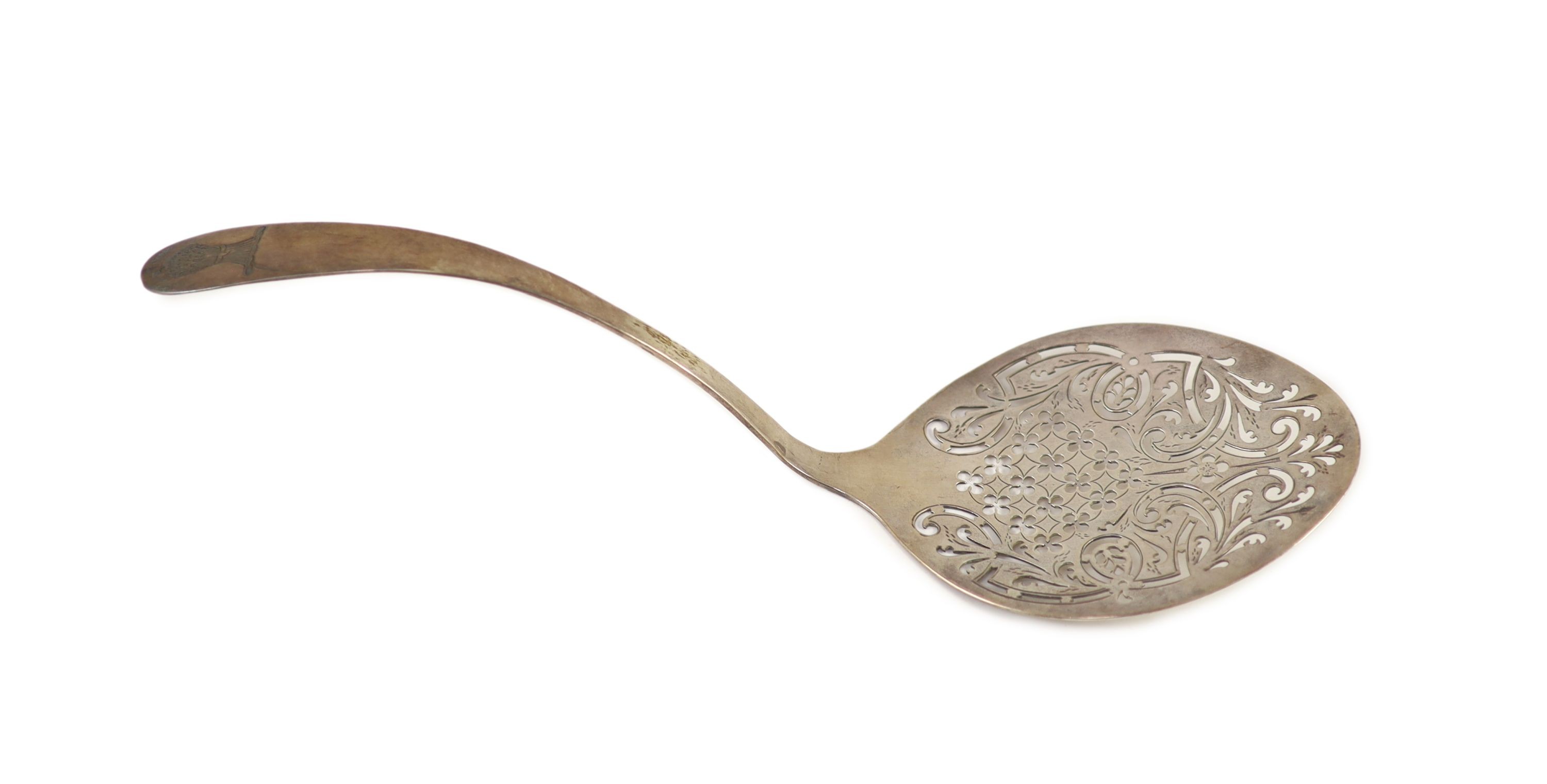 An 18th century Irish pierced silver fish serving ladle, maker W.T., marks rubbed, 30.2cm, 99 grams.