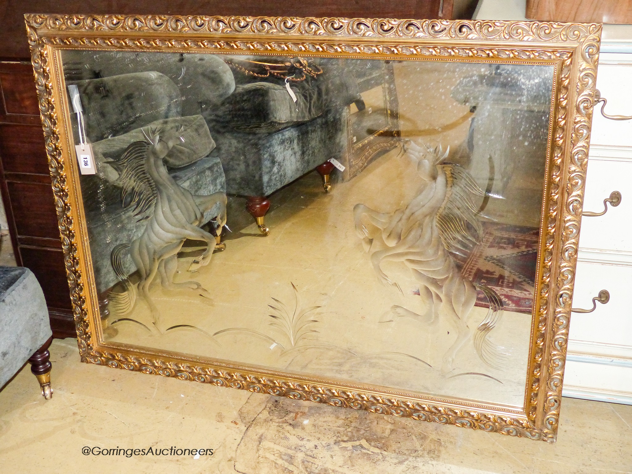 A rectangular gilt wall mirror etched with a stallion, width 120cm, height 90cm