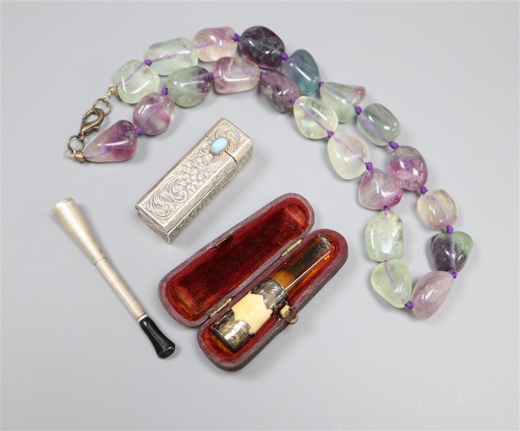 Two white metal cigarette holders, an 800 lipstick holder and a quartz necklace.