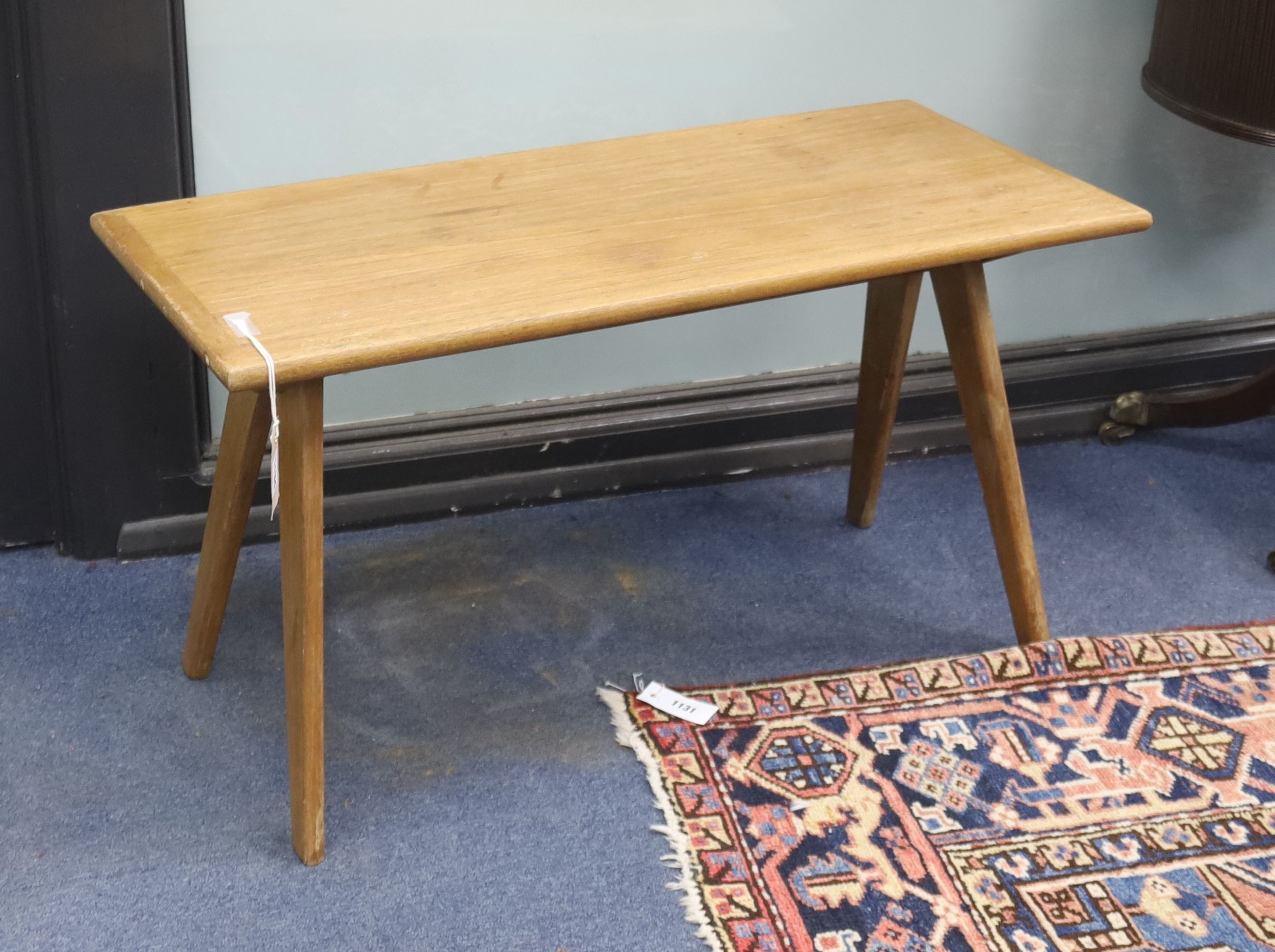 In the style of Pierre Jeanneret. A rectangular teak occasional table on compass leg, width 84cm, depth 37cm, height 46cm