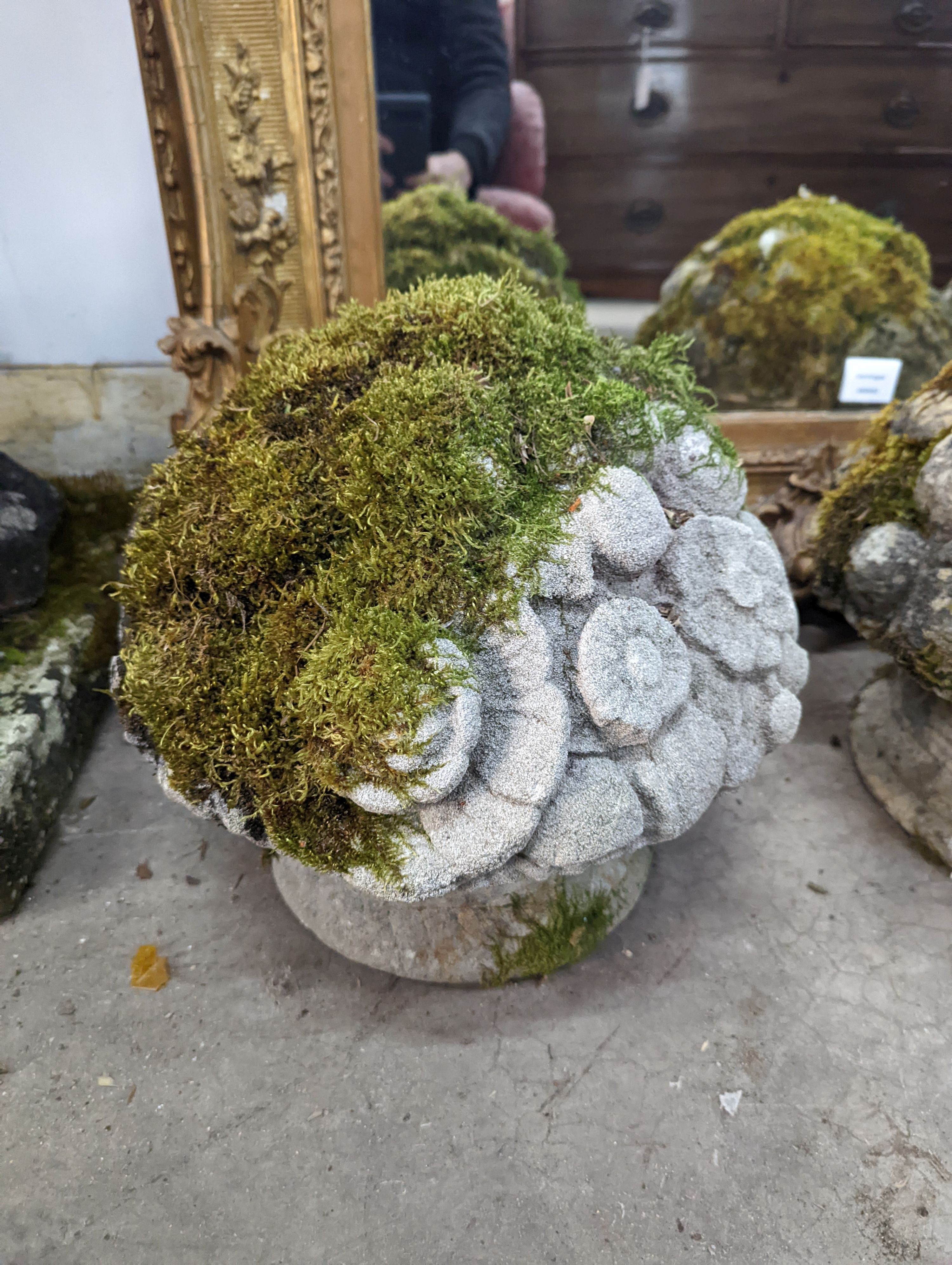 A set of three weathered reconstituted stone garden ornaments modelled as floral bunches, diameter 32cm, height 30cm