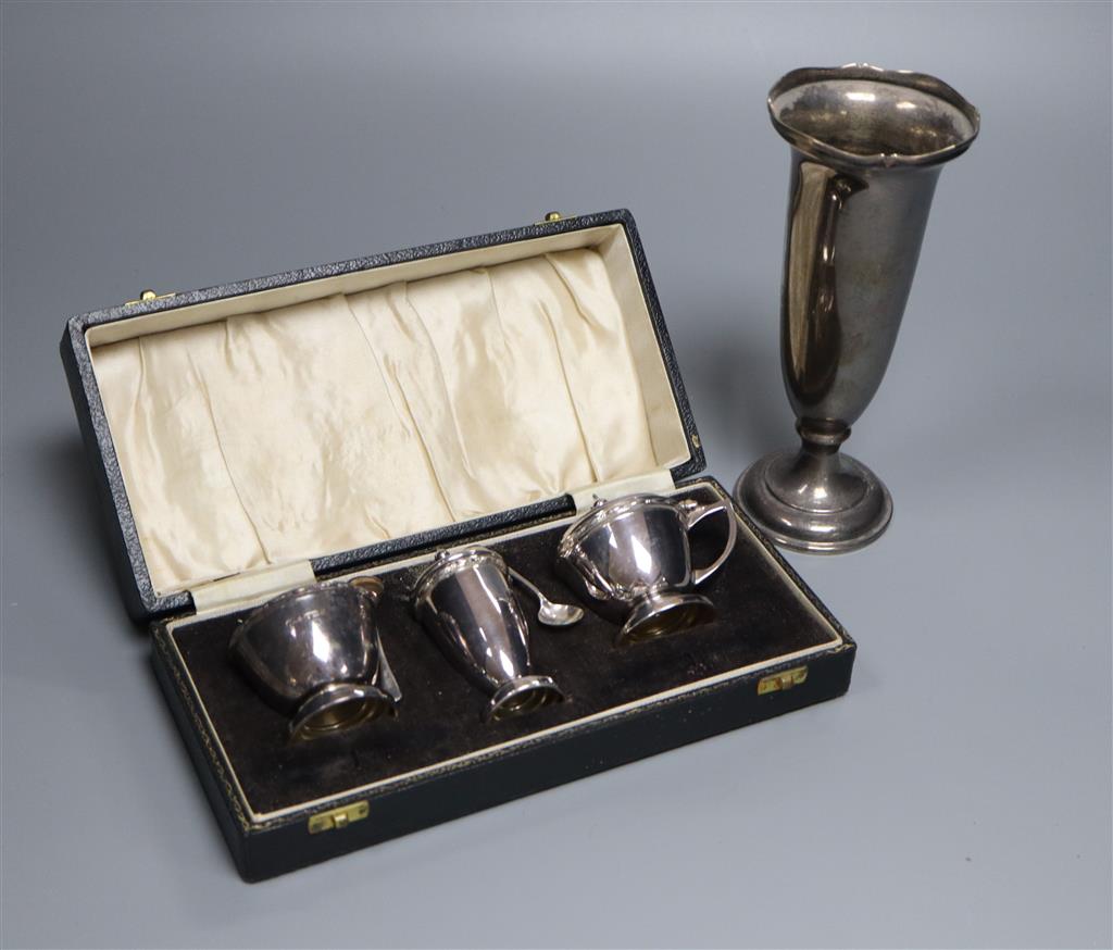 A cased modern silver three piece condiment set with two spoons and a George V silver spill vase, 18.4cm, weighted.