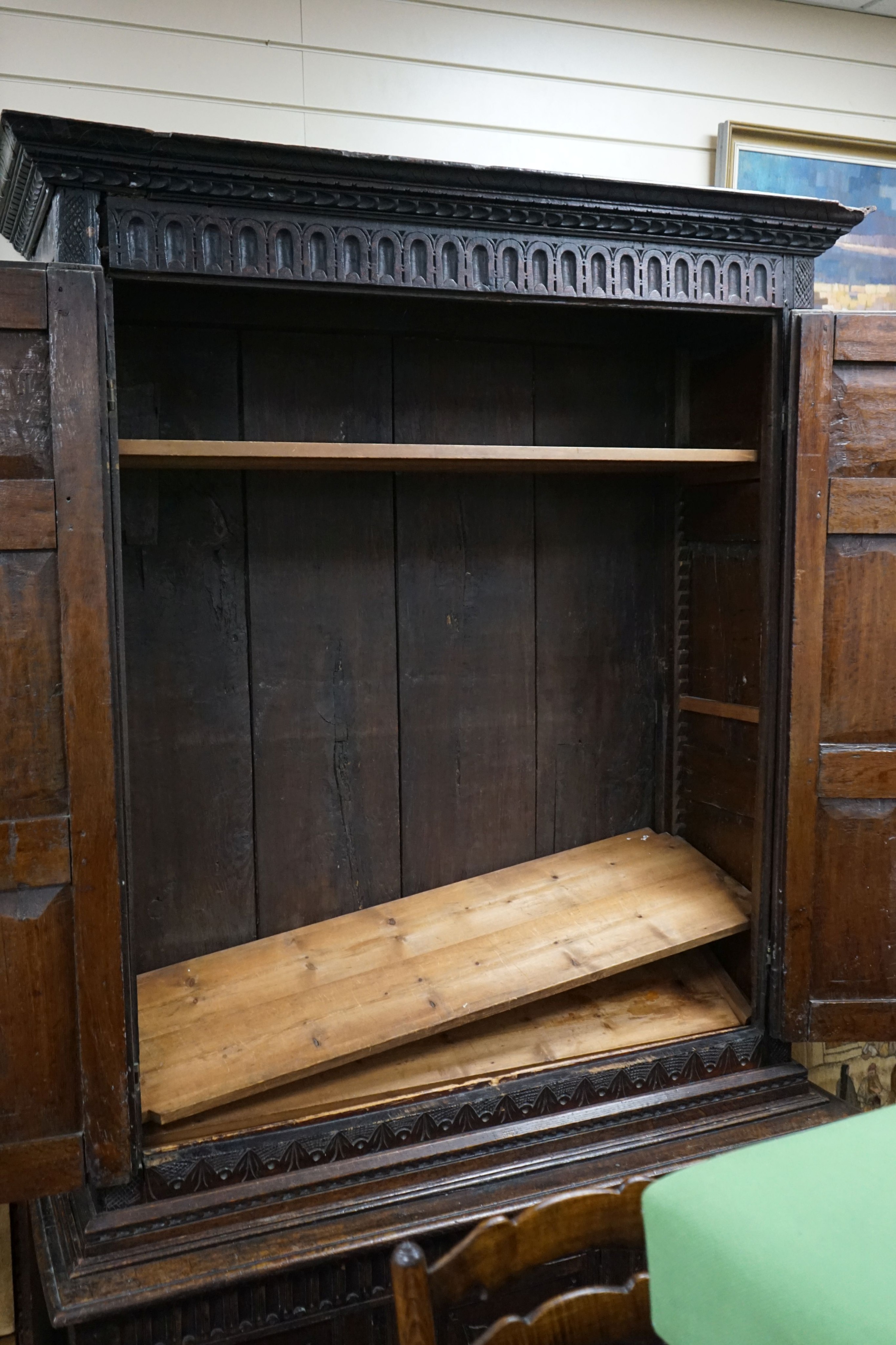A carved oak cupboard, enclosed by panelled doors, bearing monograms and dated 1601, width 138cm, depth 53cm, height 218cm