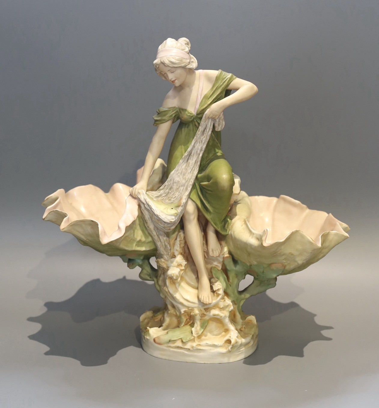 A Royal Dux porcelain centrepiece, modelled as a fisherwoman with scallop shells, height 41cm