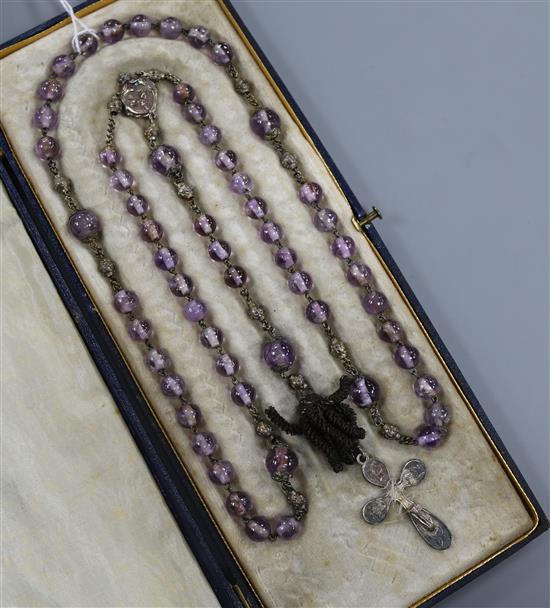 An early 20th French amethyst bead necklace, with white metal cross pendant drop, approx. 90cm. An early 20th French amethyst bead necklace, with white metal cross pendant drop, approx. 90cm.
