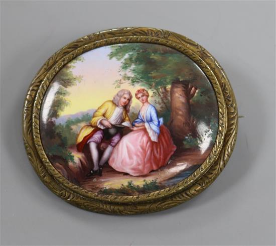 A gilt metal mounted mother of pearl oval panel, painted with lady and gentleman in woodland scene, 50mm. A gilt metal mounted mother of pearl oval panel, painted with lady and gentleman in woodland scene, 50mm.