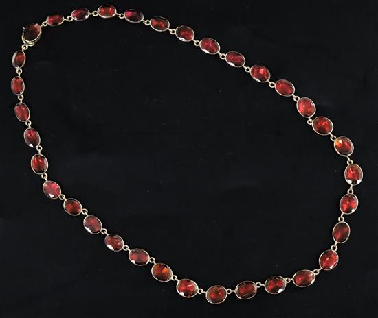 A Victorian gold and foiled back oval cut garnet necklace, approx. 36cm. A Victorian gold and foiled back oval cut garnet necklace, approx. 36cm.