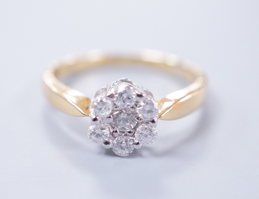 A modern 18ct gold and seven stone diamond set flower head cluster ring, size L, gross weight 2.9 grams
