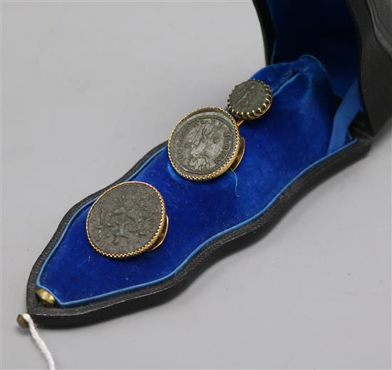 Three Roman coins, yellow metal mounted as a tie pin and button set, in French fitted box. Three Roman coins, yellow metal mounted as a tie pin and button set, in French fitted box.