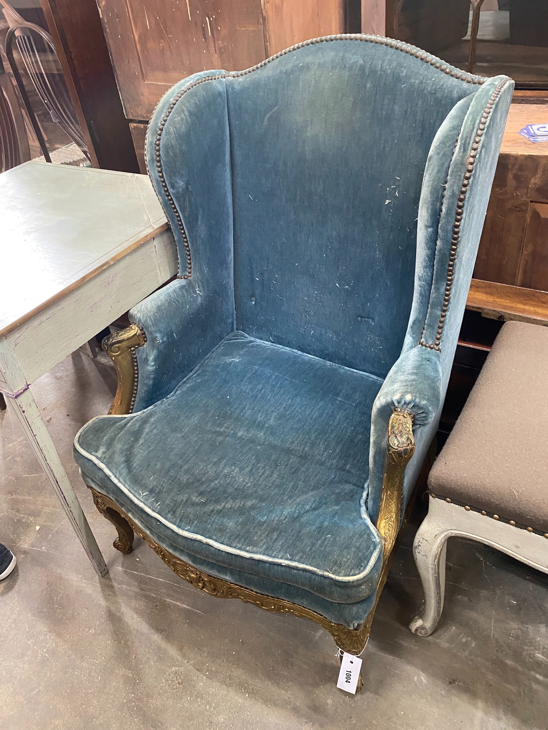 A 19th century giltwood upholstered wing armchair, width 74cm, depth 60cm, height 110cm