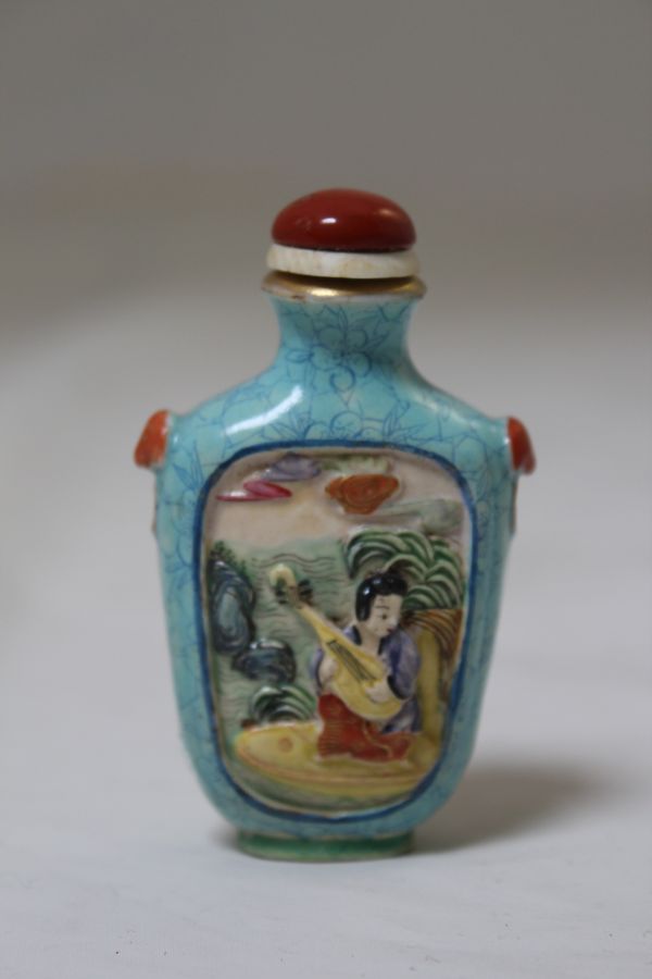 A MOLDED AND ENAMELED EXPORT-STYLE PORCELAIN SNUFF BOTTLE