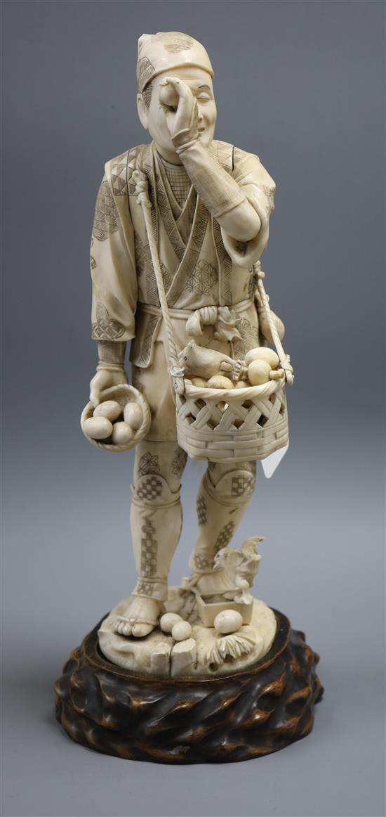A Meiji carved ivory figure of a man inspecting bird eggs, a sectional carving A Meiji carved ivory figure of a man inspecting bird eggs, a sectional carving