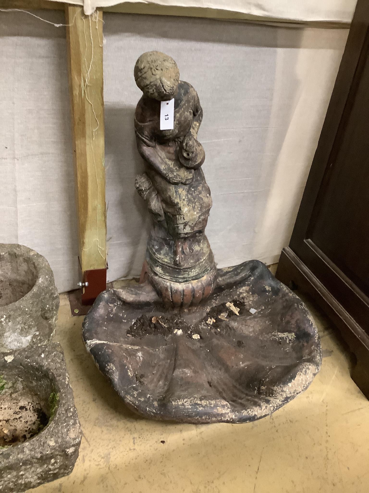 A reconstituted stone scallop shape bird bath with figural top (cracked), height 81cm
