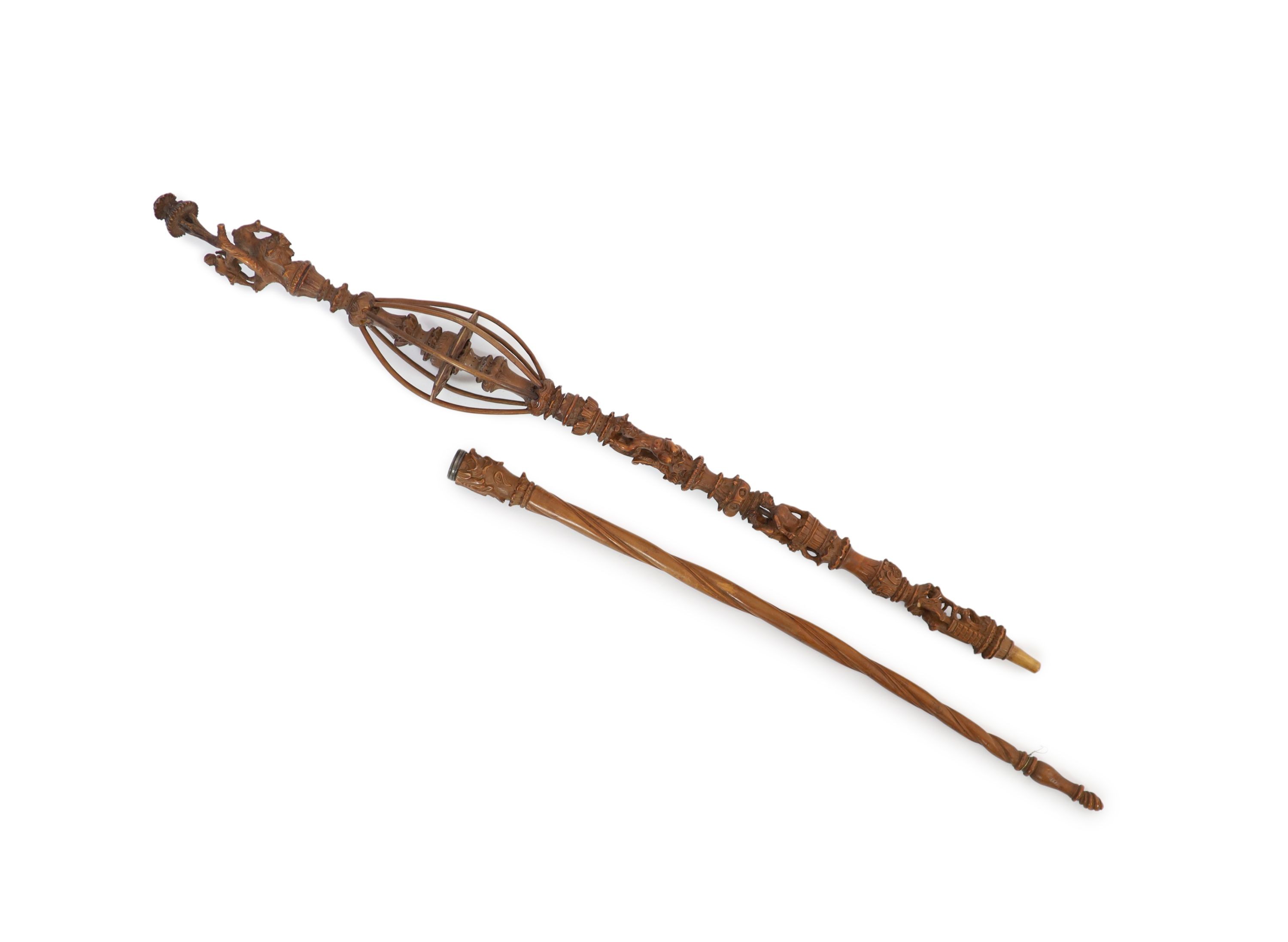 A 17th century French boxwood distaff (wool winder), carved with numerous figures and scrolls, over a spiral fluted stem, 49 & 36cm.