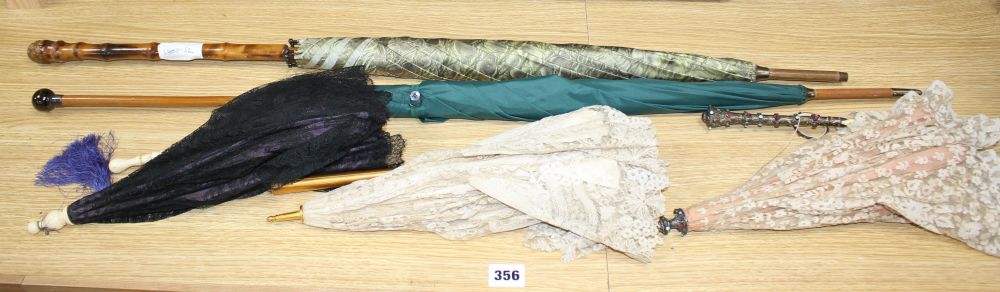 A group of assorted Victorian and later parasols including one with jewelled silver and ivory folding handle