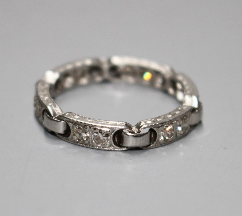 An unusual white metal (stamped Plat) and twelve stone diamond set eternity ring,