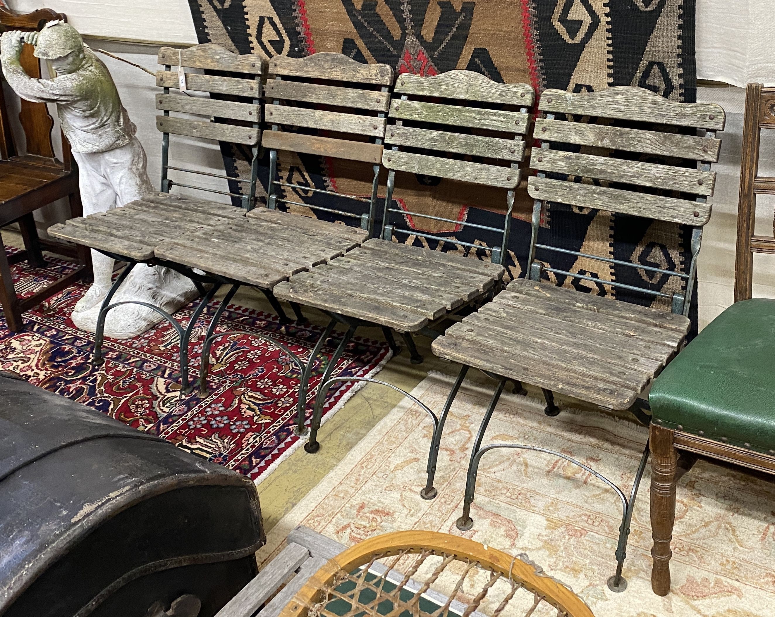 A set of four wrought iron slatted wood garden chairs