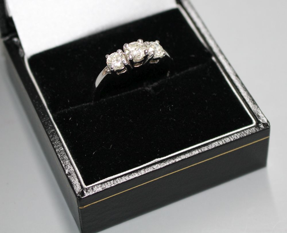 A modern 14k white metal and three stone diamond ring,