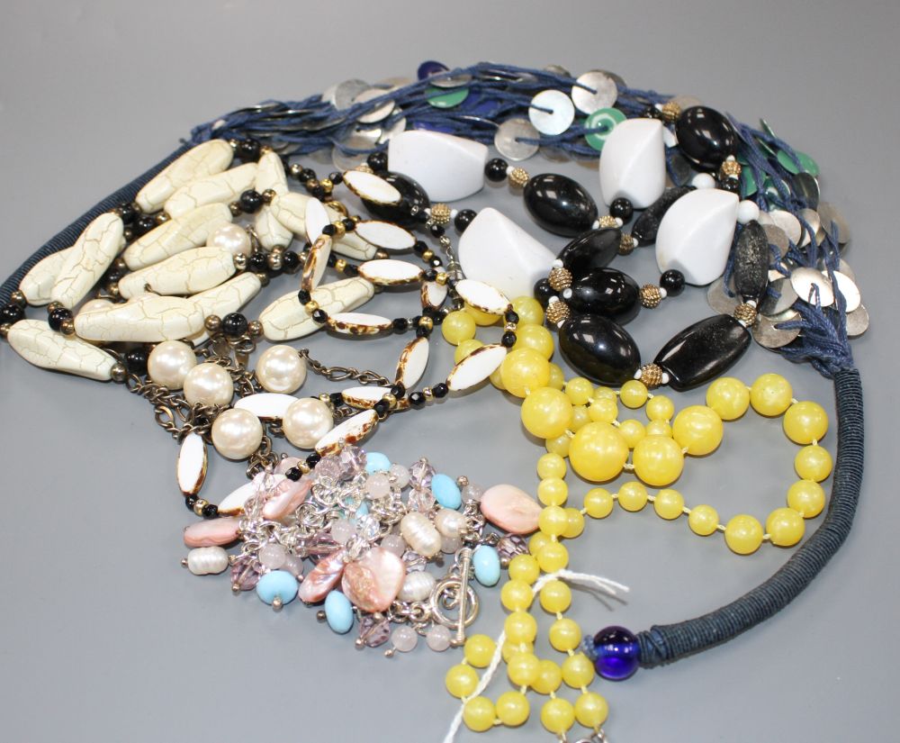 Six assorted costume necklaces including simulated amber and a costume bracelet,