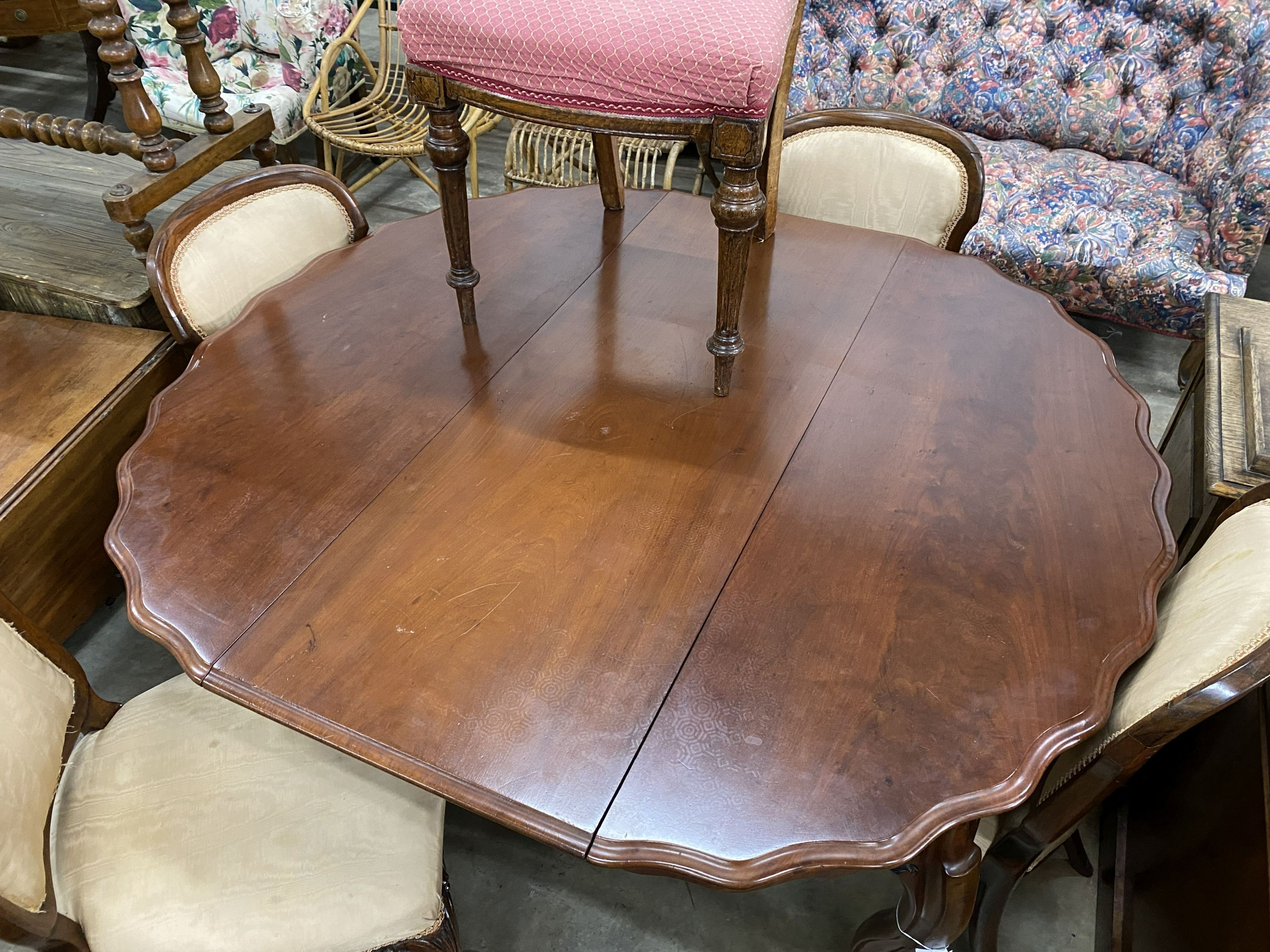 A 19th century French mahogany extending dining table on cabriole legs, width 134cm extended, one spare leaf, width 120cm, height 75cm