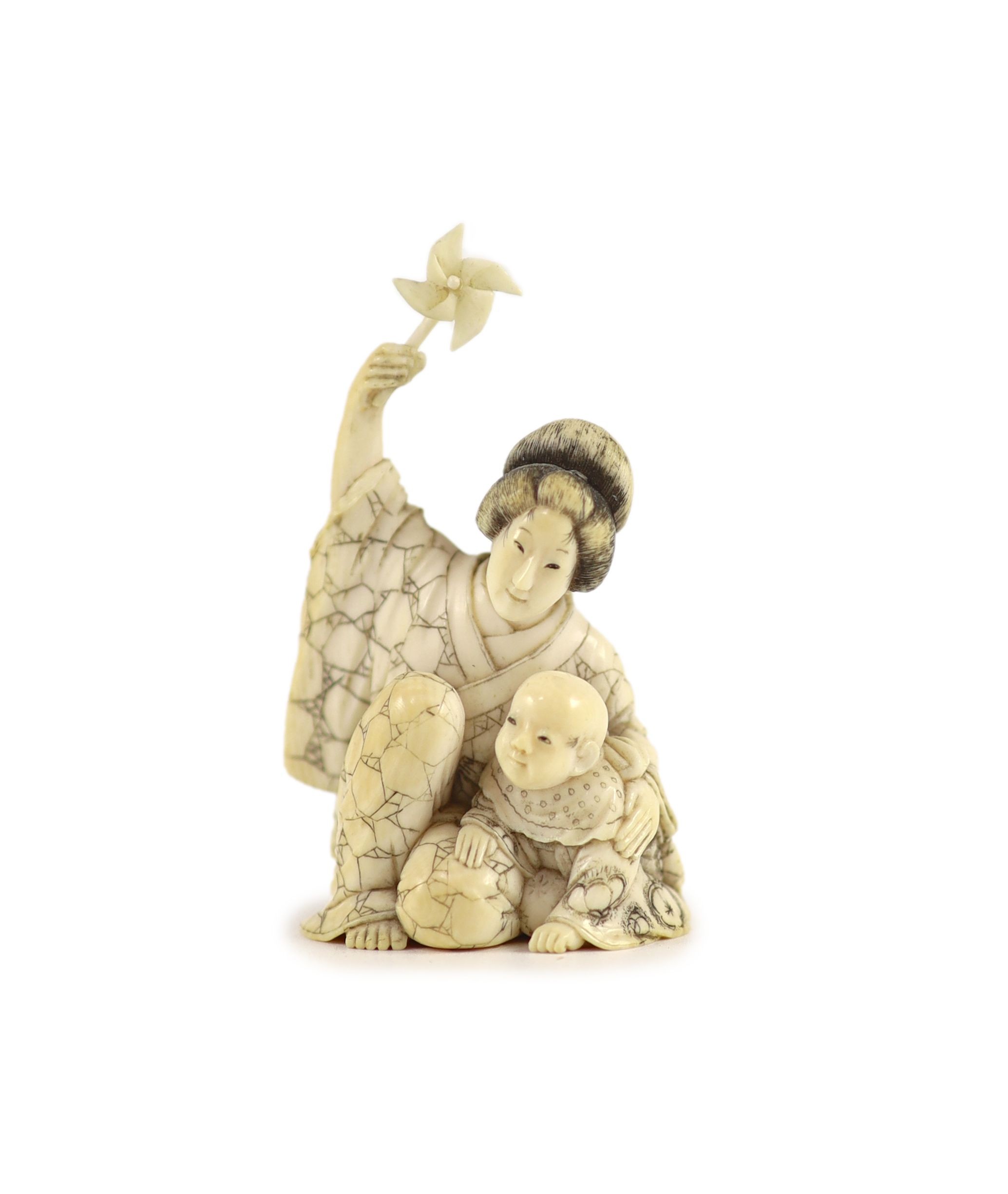 A Japanese ivory okimono of a mother and child, Meiji period, 6.4 cm high