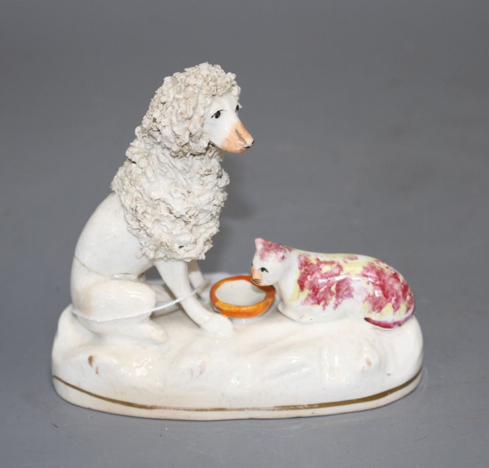 A rare Staffordshire porcelain group of a poodle and a cat sharing a bowl, c.1835-50, H. 10cm
