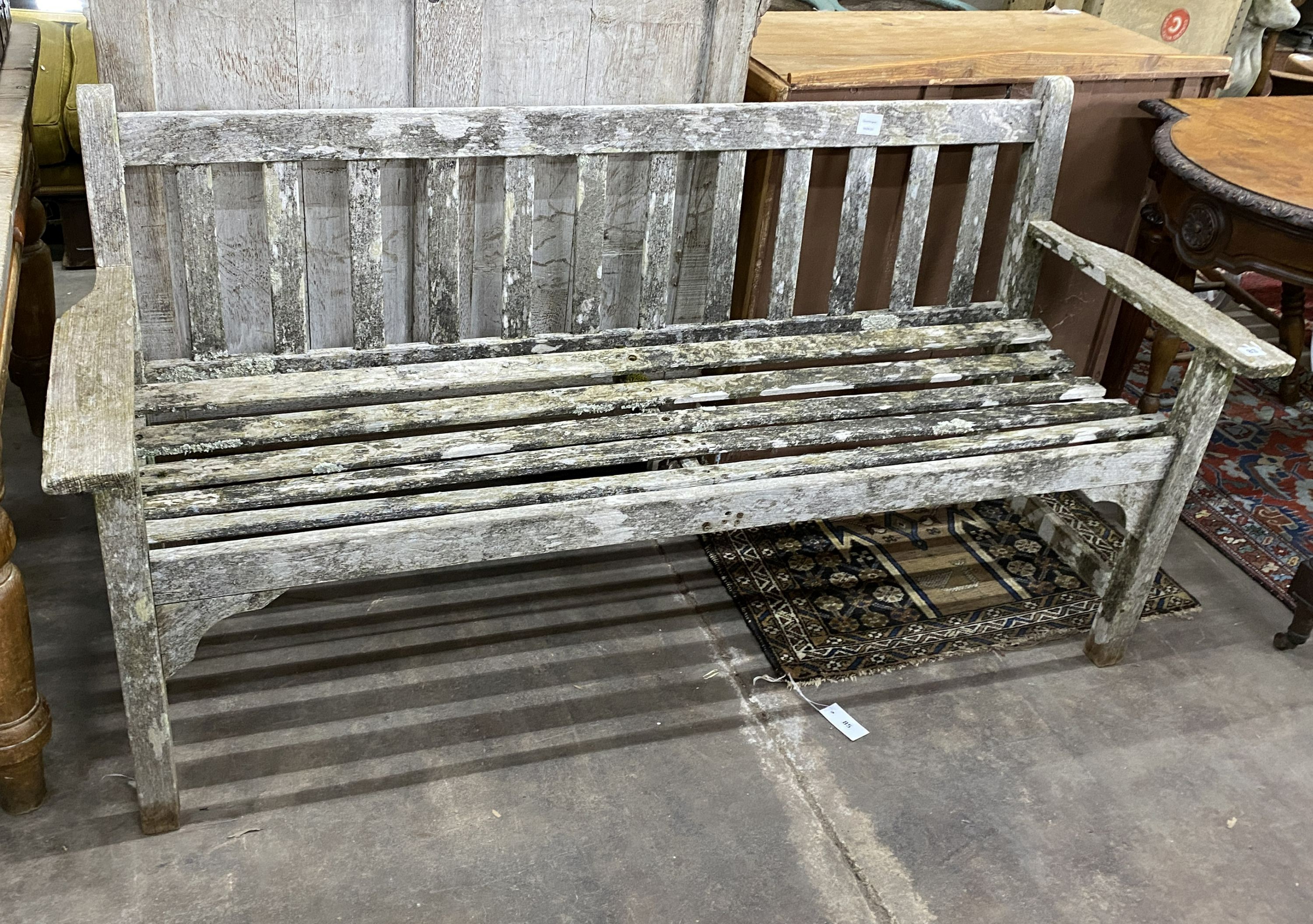A weathered teak slatted garden bench, length 160cm, depth 54cm, height 82cm