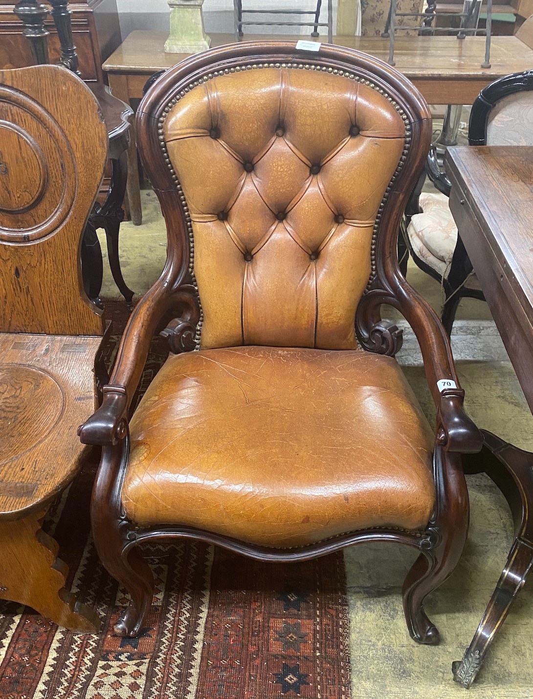 An early Victorian mahogany open armchair upholstered in tan leather, width 60cm, depth 42cm, height 94cm