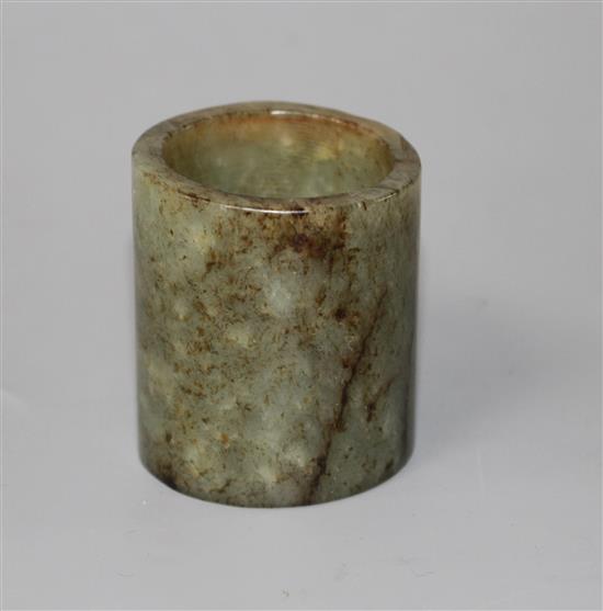 A Chinese celadon and brown jade cylinder, probably archaic, H. 4.6cm