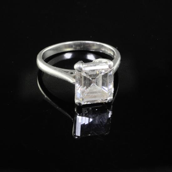 A modern platinum and emerald cut solitaire diamond ring, size F.